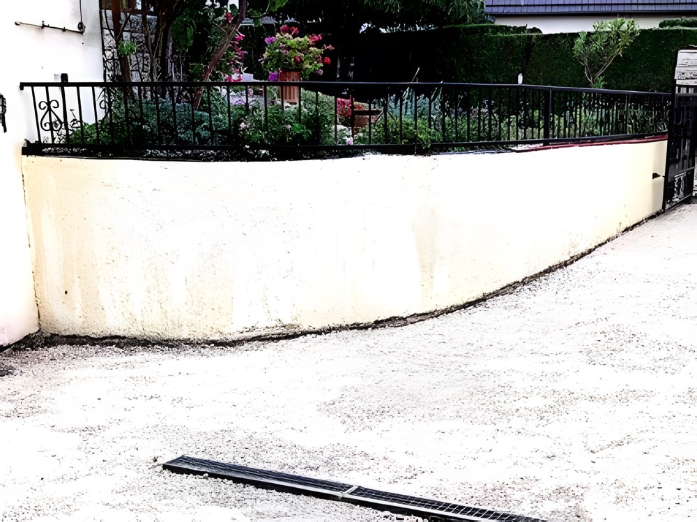 Muret enduit surmonté d'une grille en fer forgé