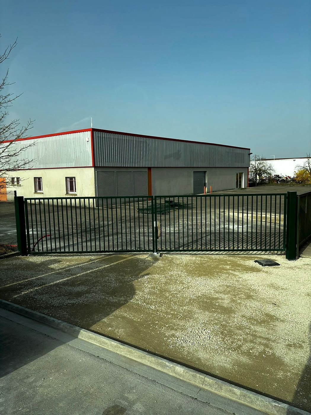 Portail industriel de 8 mètres fabriqué et posé à l'entrée d'un entrepôt
